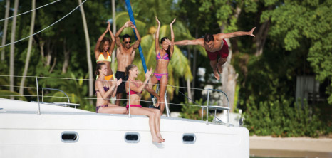Guests on Board Good Times Catamaran Cruises Cheering and Having a Great Time While One of Their Friends Dives Into the Ocean, Barbados Pocket Guide