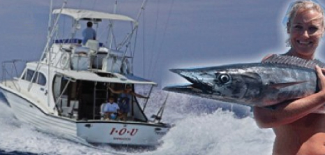 Lady in the Foreground Holding the Catch of the Day, While IOU Charters Sails Away in the Background, Barbados Pocket Guide
