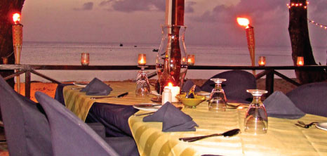 Dinner Tables Set Amidst a Backdrop of Burning Bamboo Torches, Il Tempio Restaurant, Fitts Village, St. James, Barbados Pocket Guide